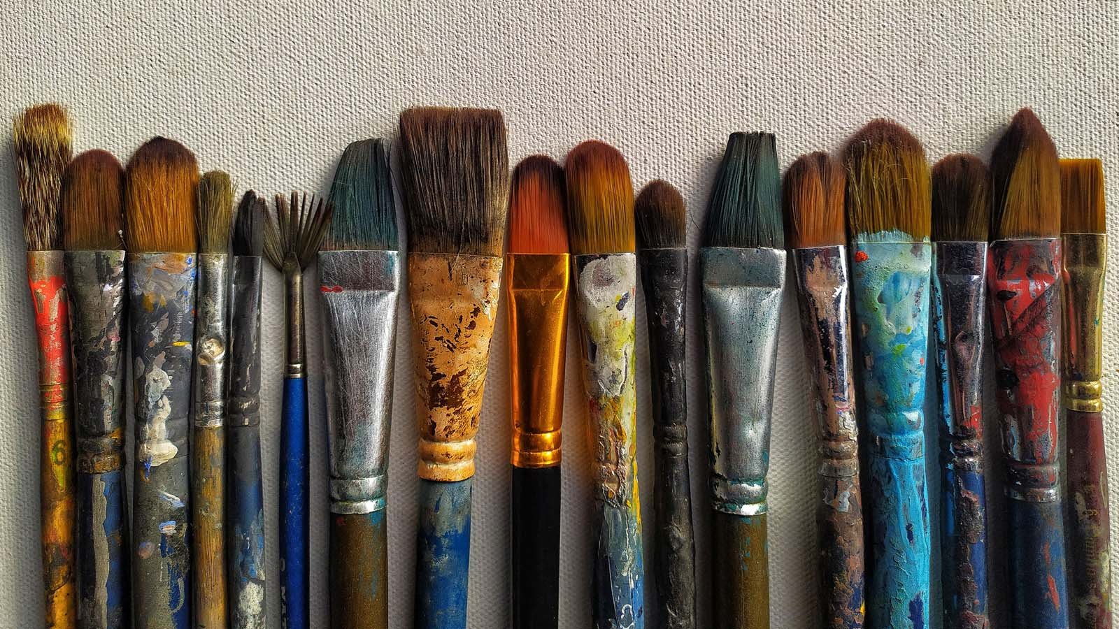 A picture of a row of used paint brushes